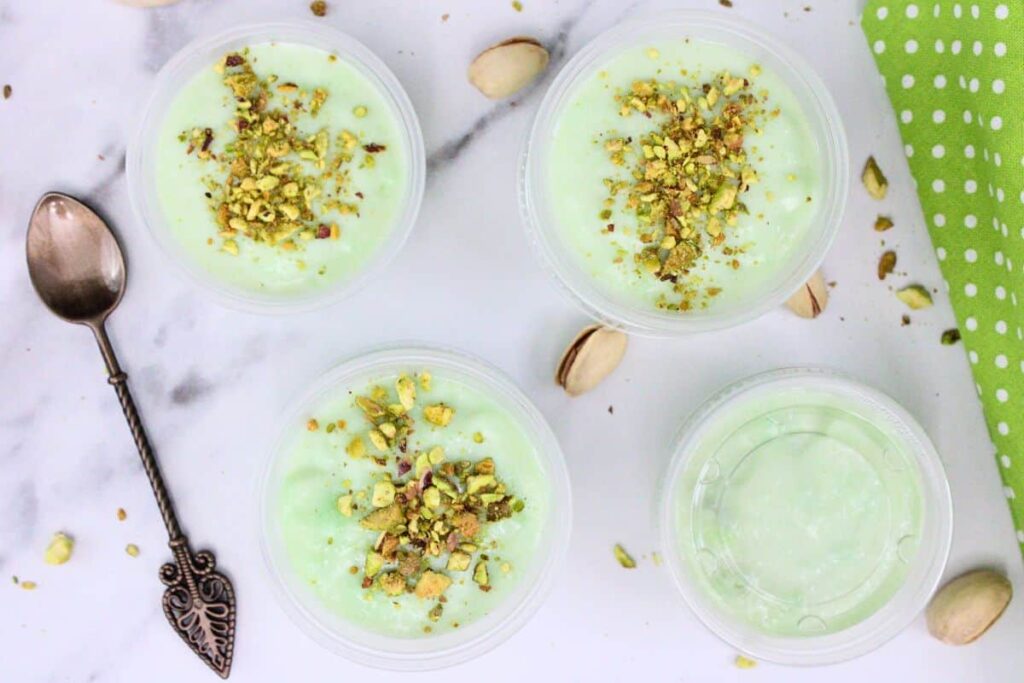 overhead view of several pistachio pudding shots with crumbled nuts on top