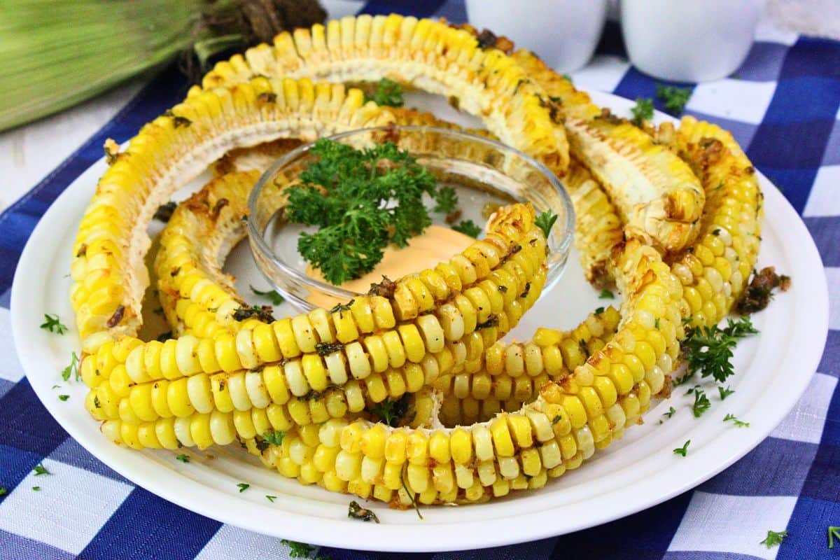 plate of air fryer corn ribs brushed with cajun butter and parsley garnish