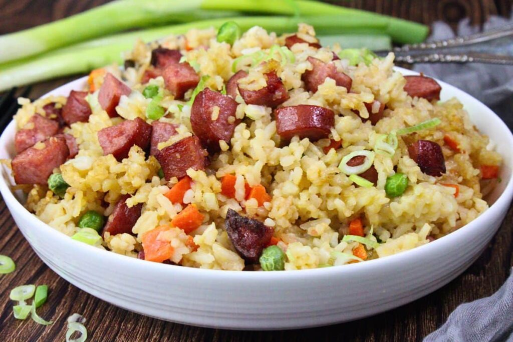 closeup view of air fryer kielbasa fried rice in a white shallow bowl