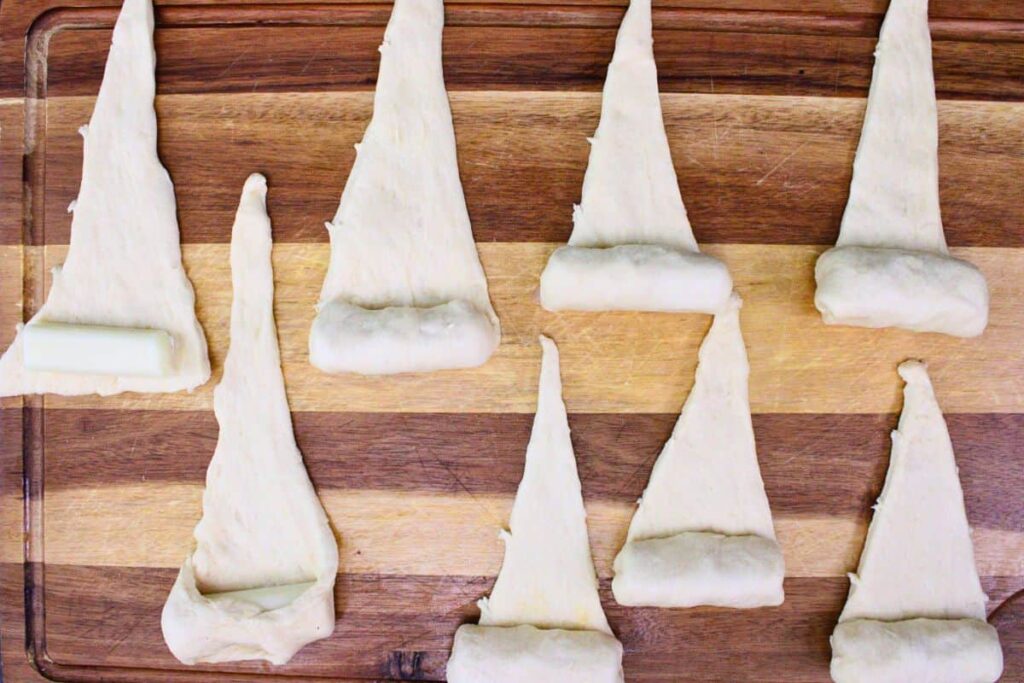separate crescent dough into triangles and add mozzarella to the bottom half