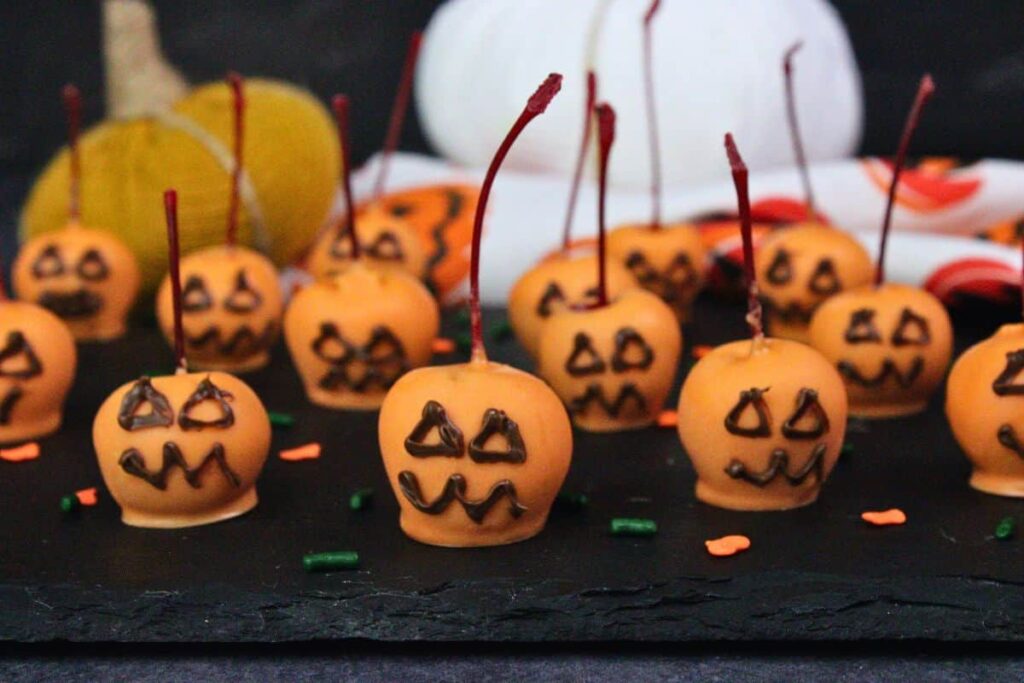 closeup of pumpkin chocolate covered cherries with chocolate faces