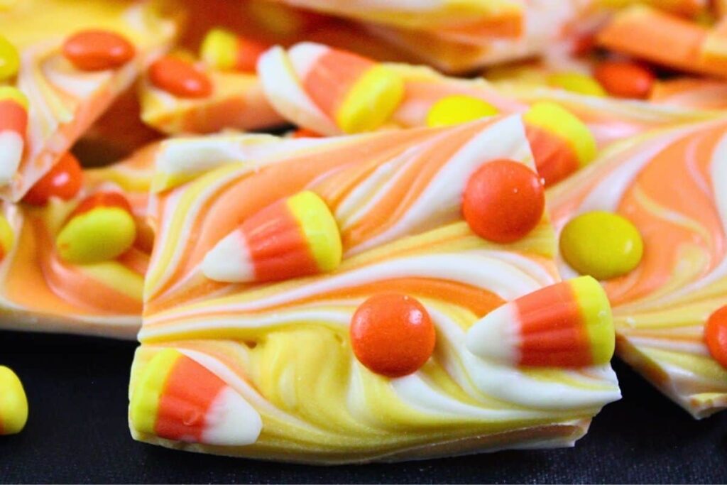 closeup view of a piece of candy corn bark showing color swirls and candy pieces