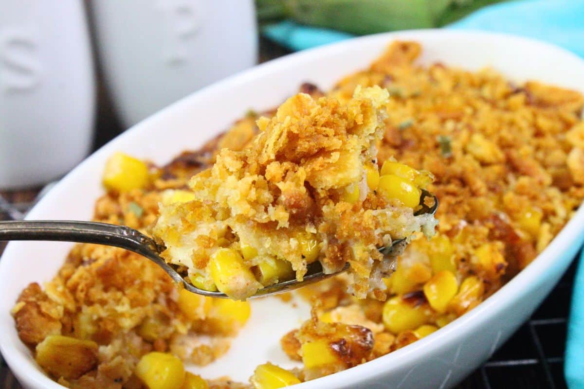 holding up a spoonful of buttery scalloped corn
