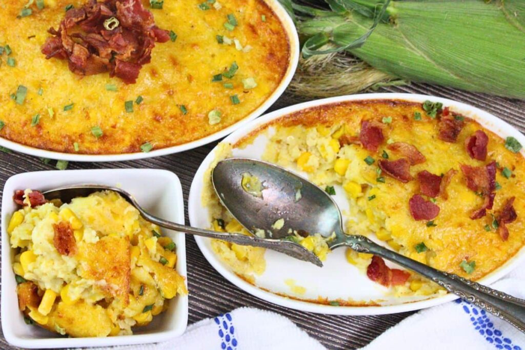 overhead view of corn pudding being served with a spoon showing off crispy bacon on top