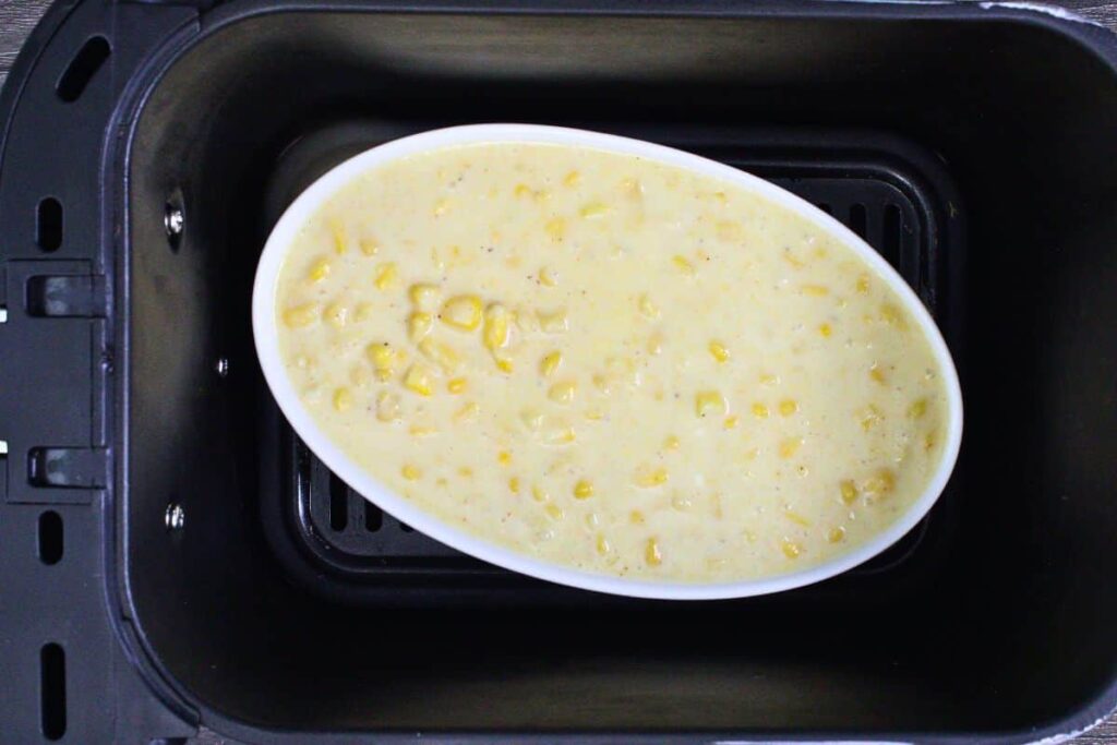 place filled corn pudding casserole dish in air fryer basket