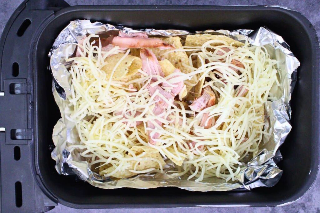 spread half tortilla chips with half shredded cheese and cooked turkey