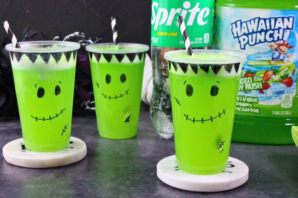 three frankenstein floats with striped straws in front of sprite and hawaiian punch bottles