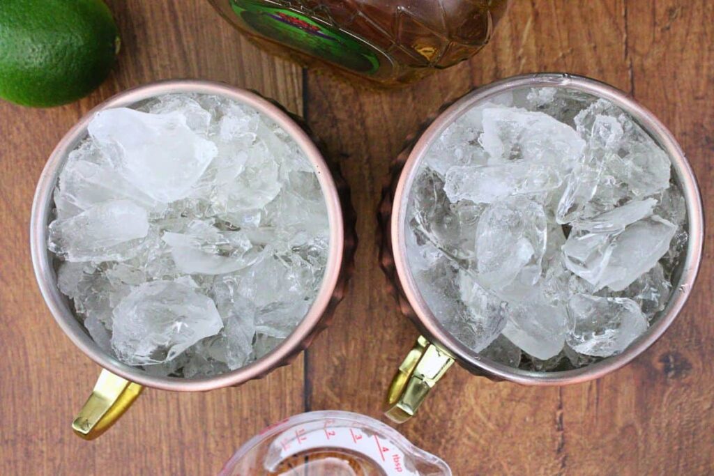 add crown apple whisky and lime juice to copper mug