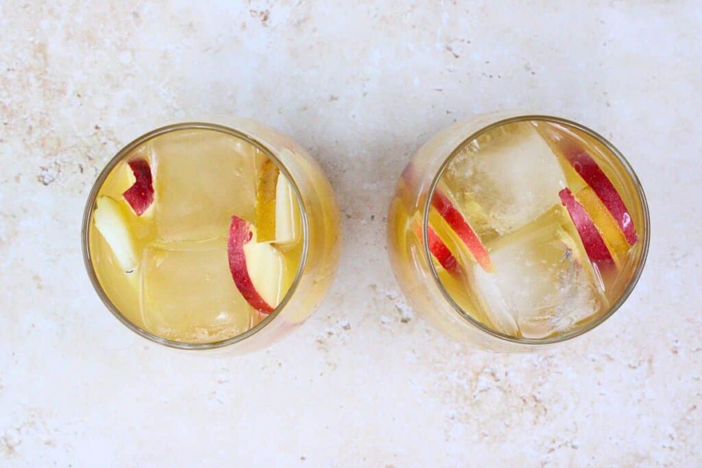 fill apple cider sangria with ice and apple and pear slices