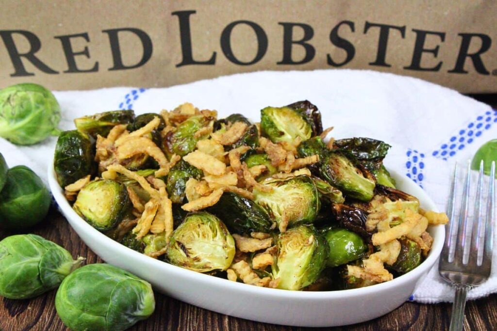 oval serving dish filled with red lobster brussel sprouts showing french fried onions on top