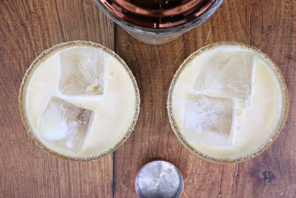 shake and strain apple pie cocktail into rimmed glasses