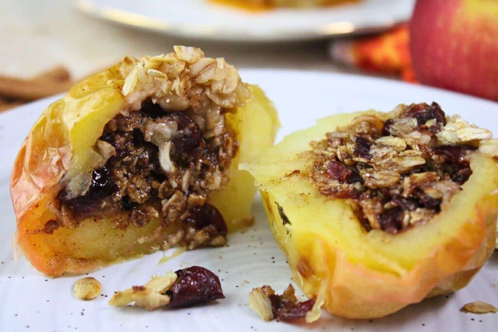 sliced open air fryer baked apple showing buttery oats and dried cranberries