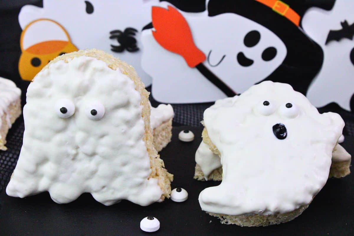 two different ghost rice krispie treats sitting in front of halloween decorations