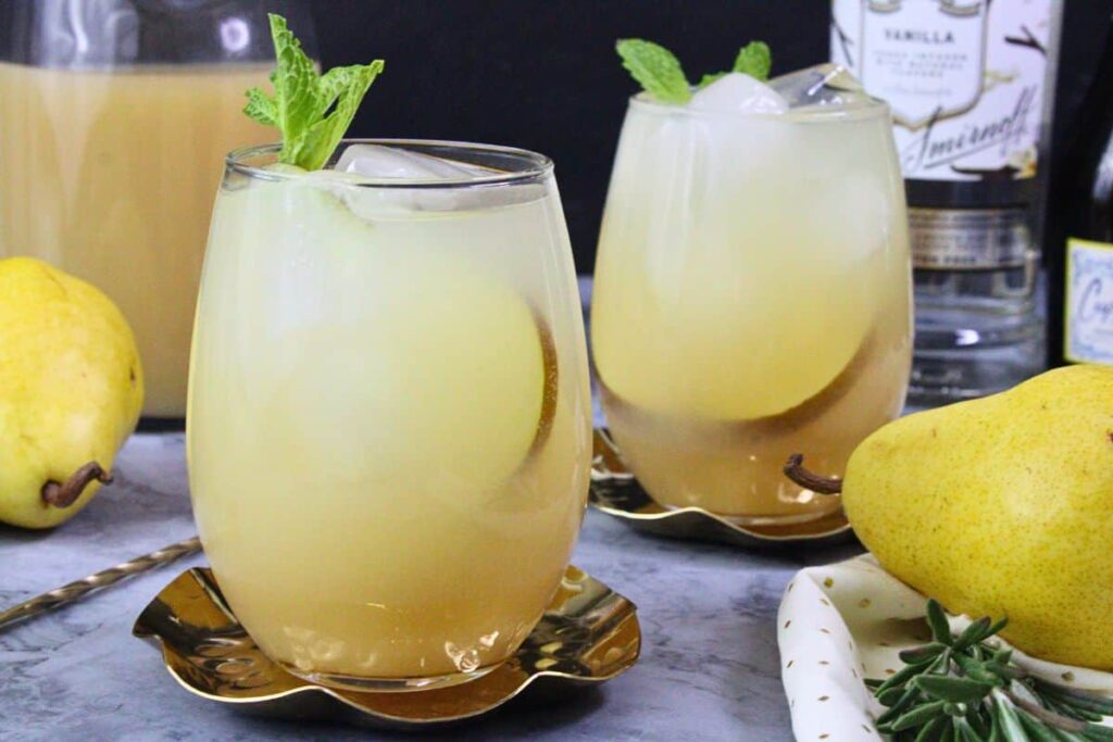 two pear spritz drinks with fresh pear slices and mint garnish