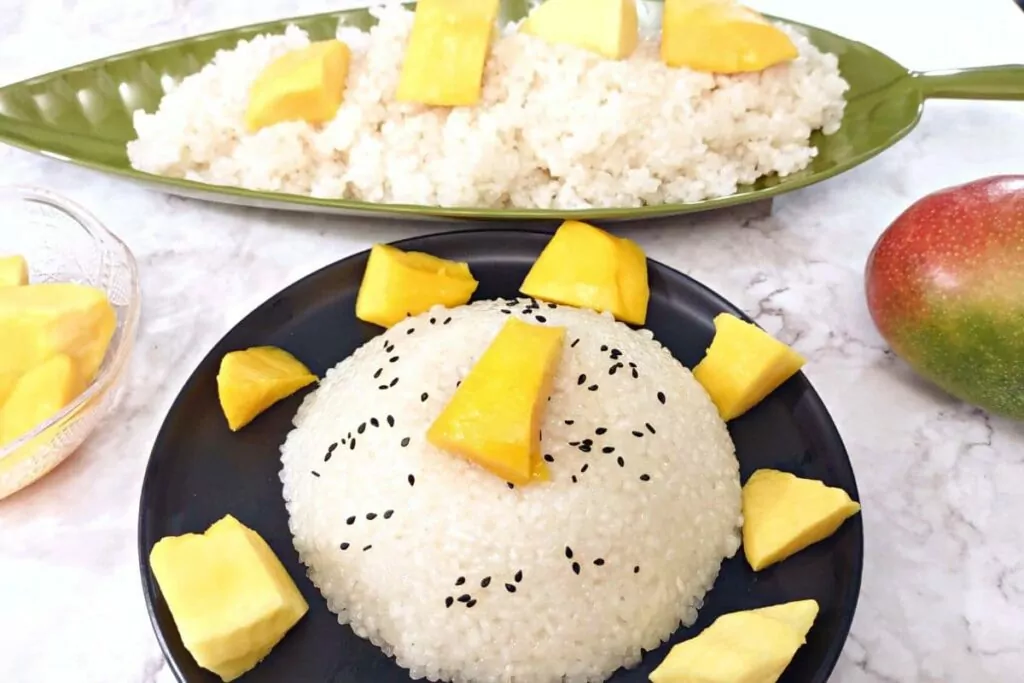 microwave sticky rice in a dome surrounded by mango chunks