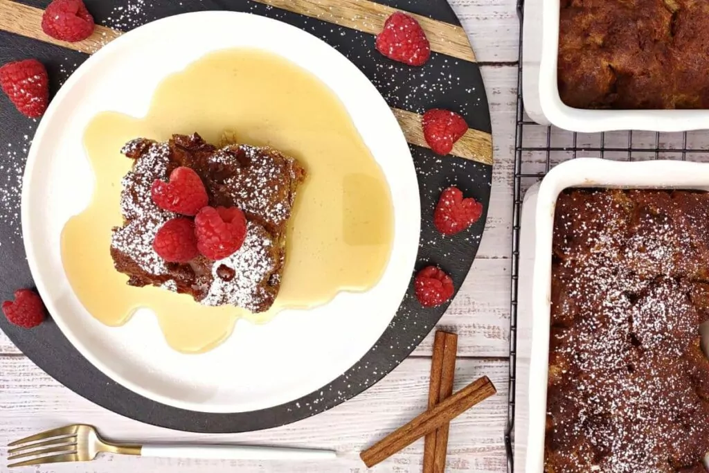 overhead view of air fryer french toast casserole on a plate with syrup and raspberries