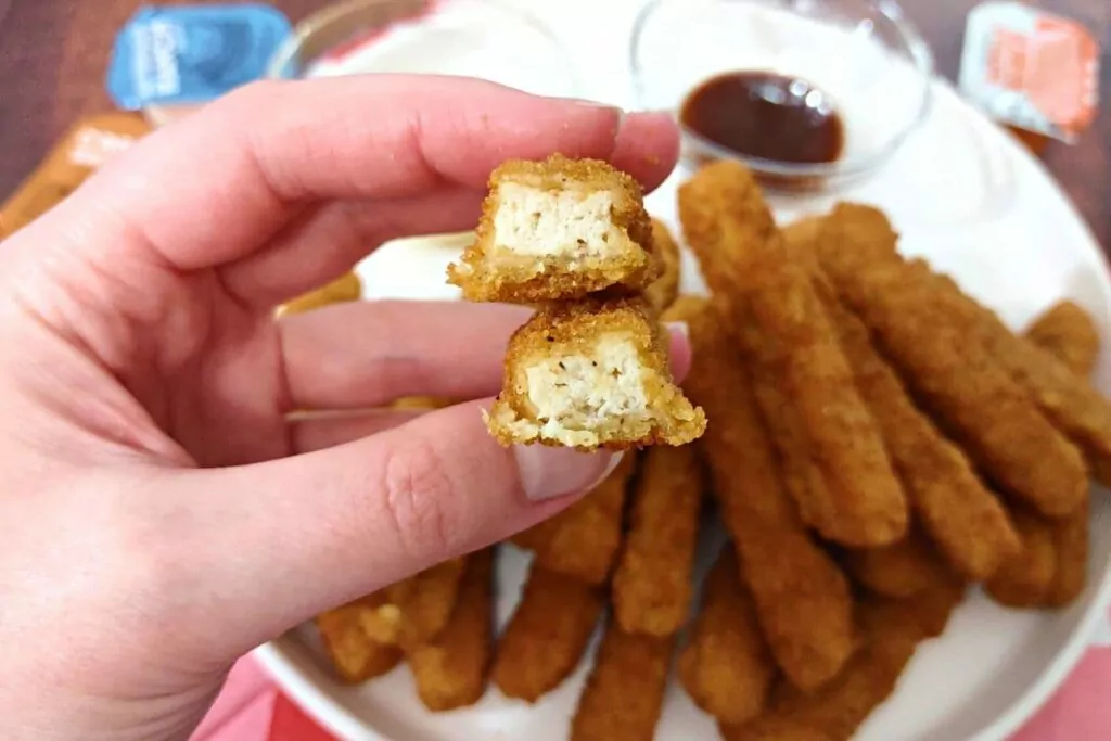 holding up a split in half air fried chicken fry