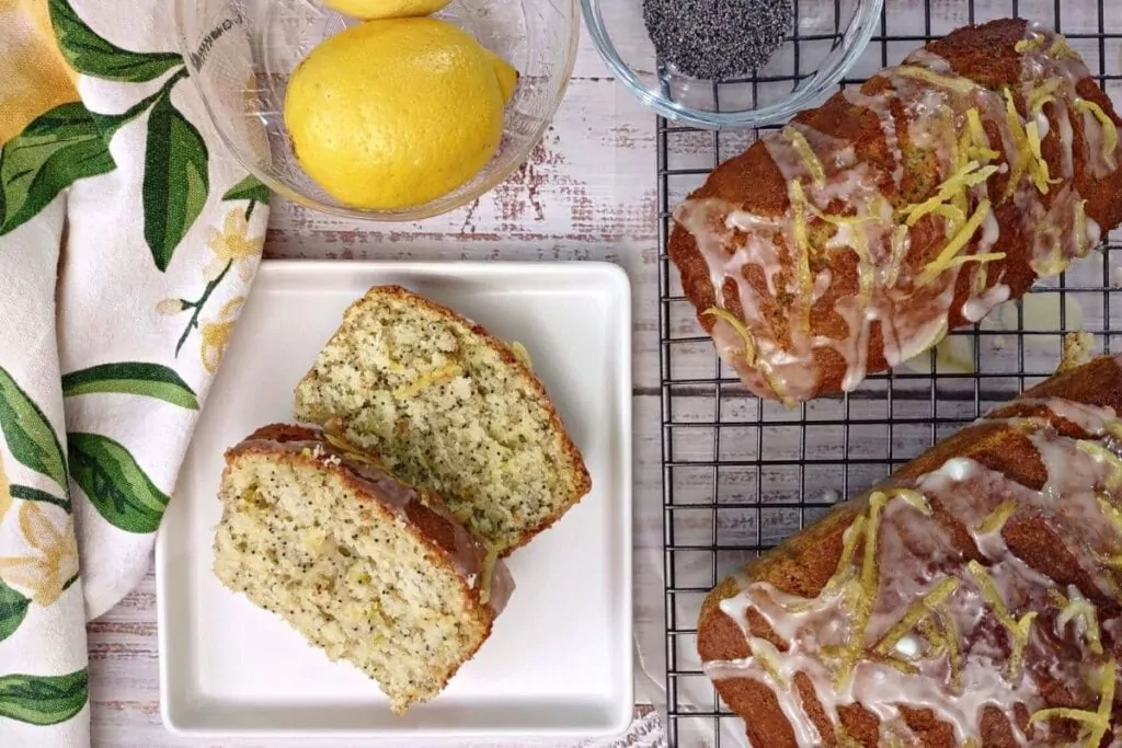 overhead view of slices of air fryer lemon poppy seed bread next to glazed loafs