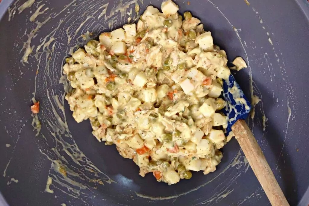 in a bowl mix carrots, peas, chicken, soup, and seasonings