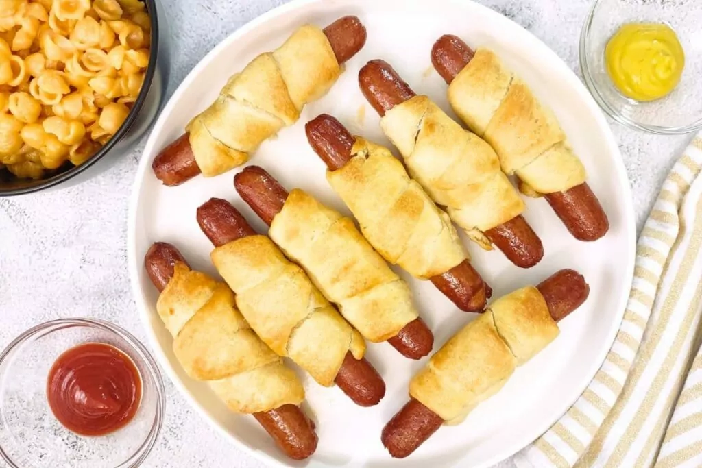 overhead view of air fryer crescent dogs on a plate with ketchup and mustard
