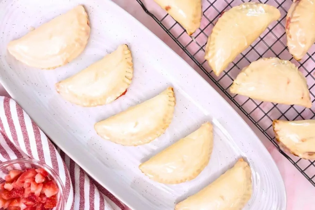 overhead view of strawberry hand pies lined across a serving plate