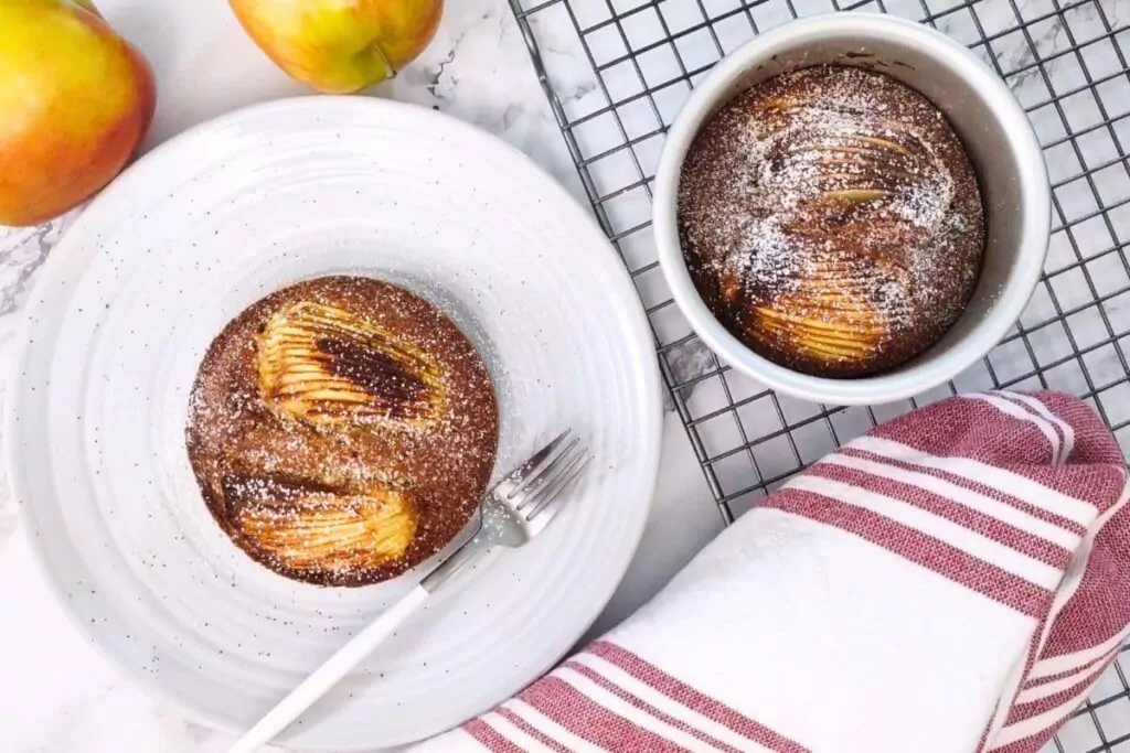 overhead view of air fryer apple cake on a plate with powdered sugar