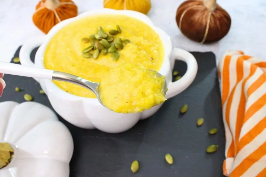 holding up a spoonful of fresh homemade air fryer pumpkin soup