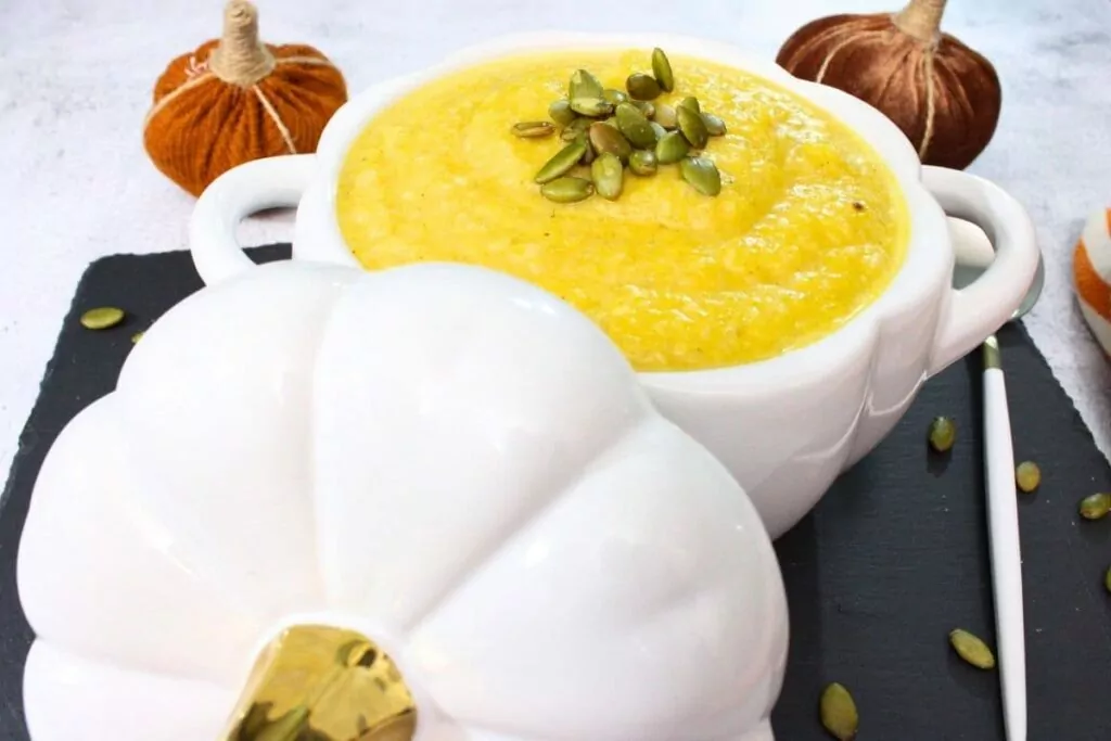 removing the ceramic lid from a bowl of air fryer pumpkin soup
