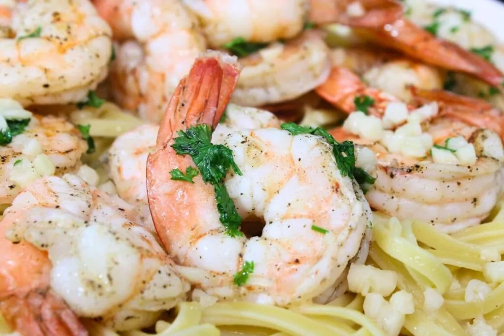 closeup view of air fryer shrimp scampi on a plate with pasta noodles