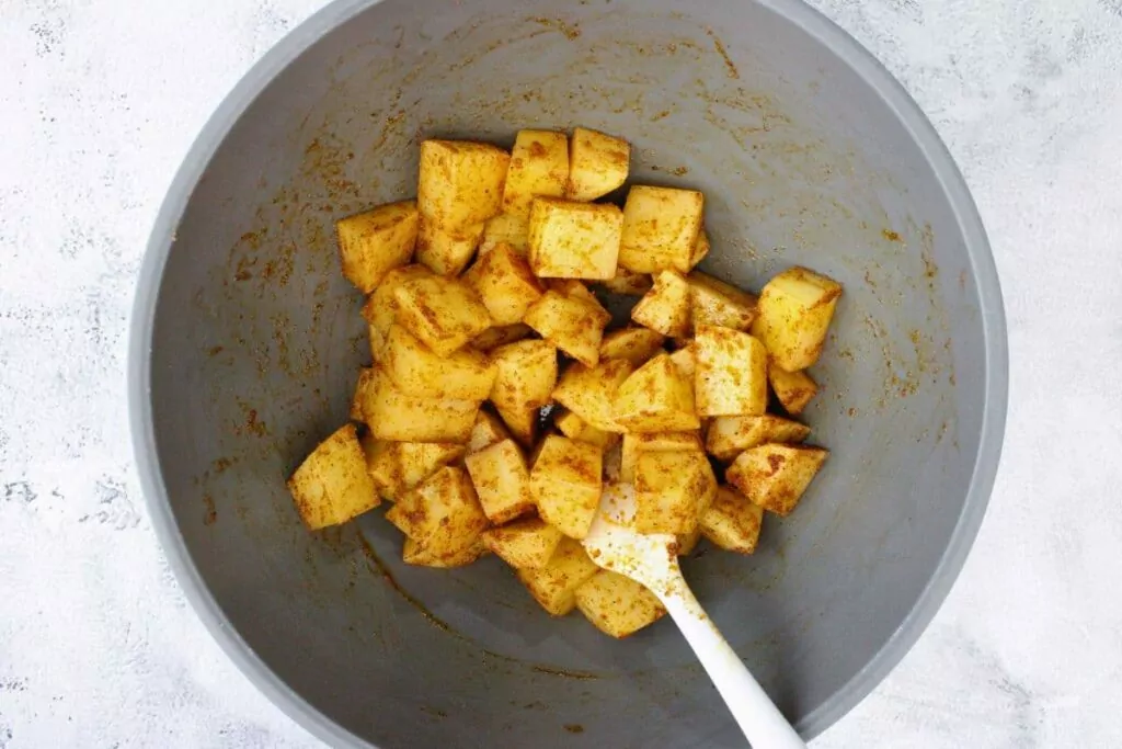 toss cubed potatoes in olive oil, salt, pepper, garlic powder, onion powder, and paprika