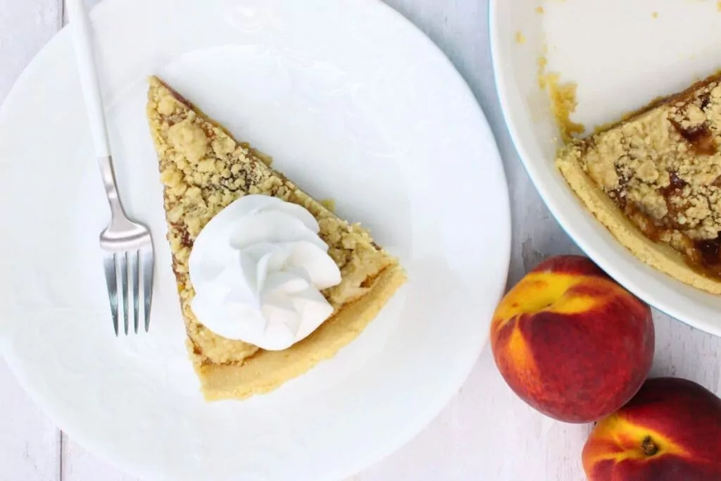 overhead view of microwave peach pie on a plate with whipped cream on top