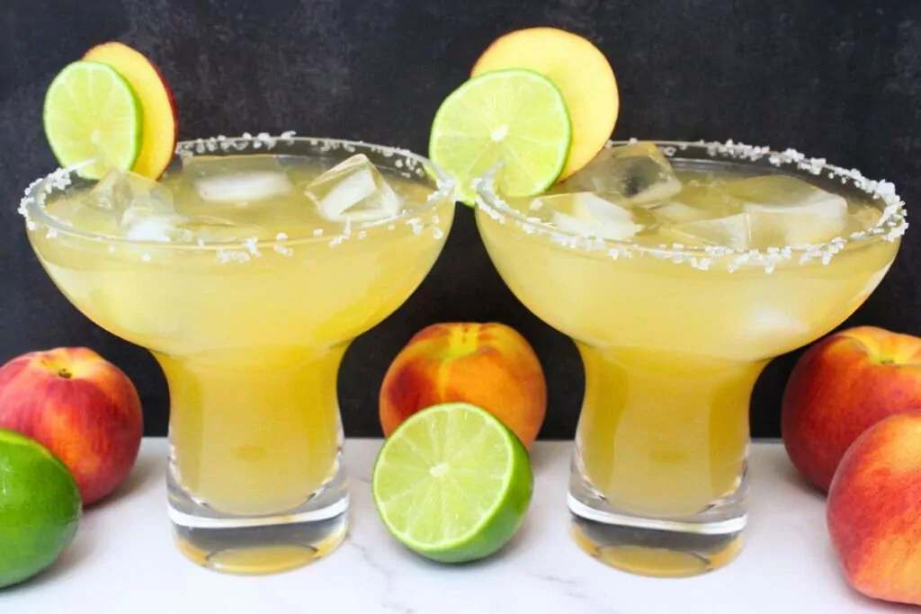 two crown peach margaritas against a dark background