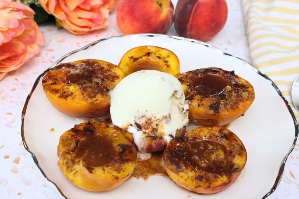 microwave baked peaches circling a plate with a center of vanilla ice cream