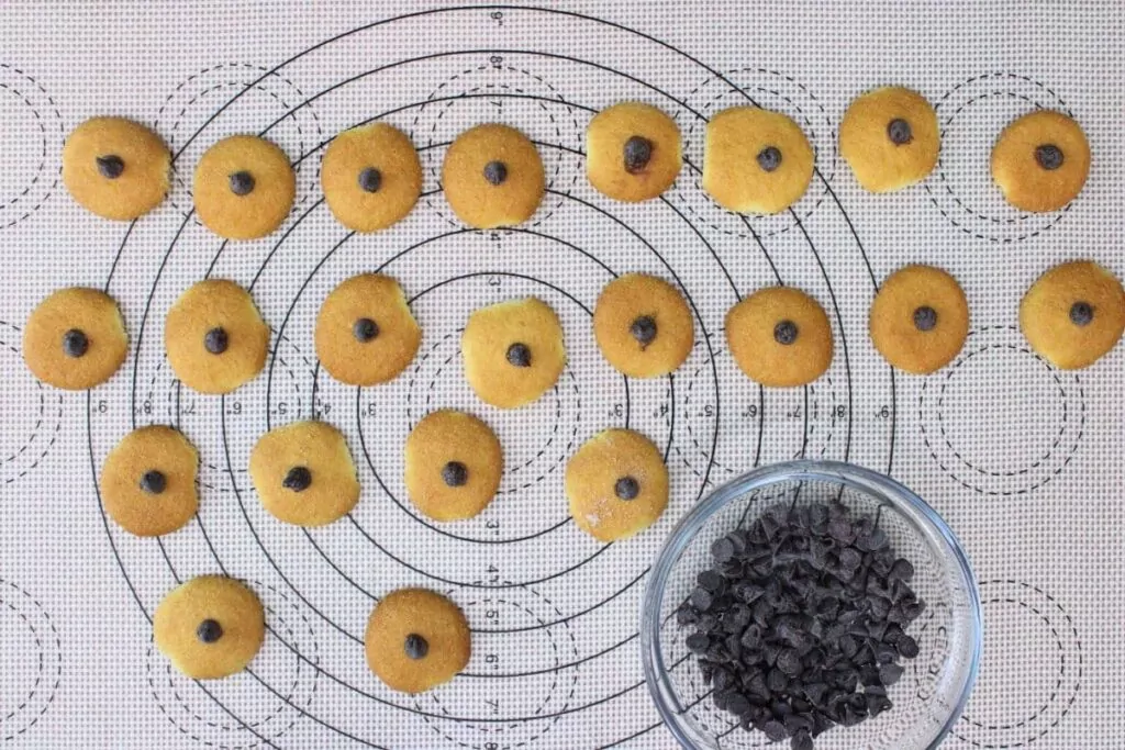 dip the base of a mini chocolate chip in the melted chocolate and place in the center of the nilla wafer on rounded side