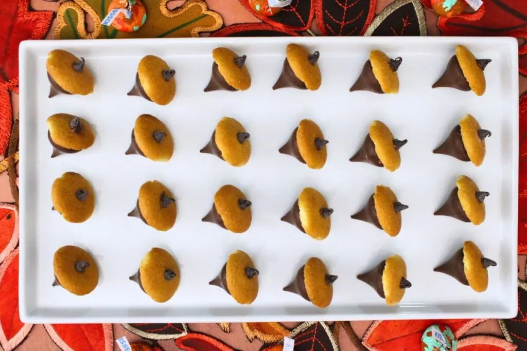 overhead view of hershey kiss acorns spread across a white square plate