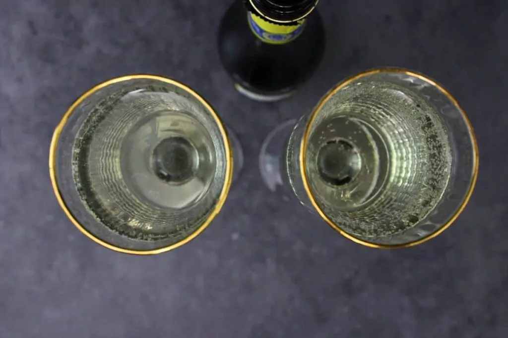 pour chilled champagne over white cranberry juice