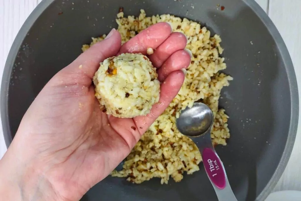 roll rice around the mozzarella cube to form a ball