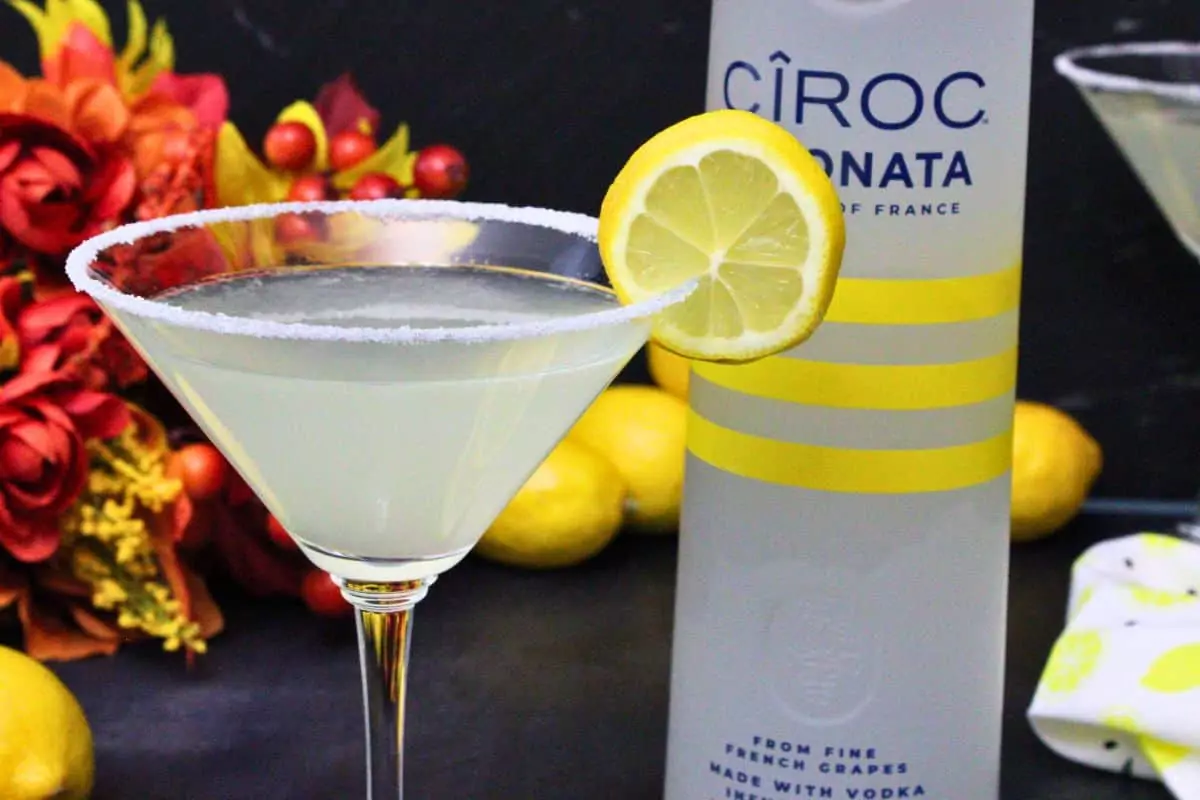 closeup view of ciroc lemon drop garnished with lemon slice next to ciroc limonata bottle