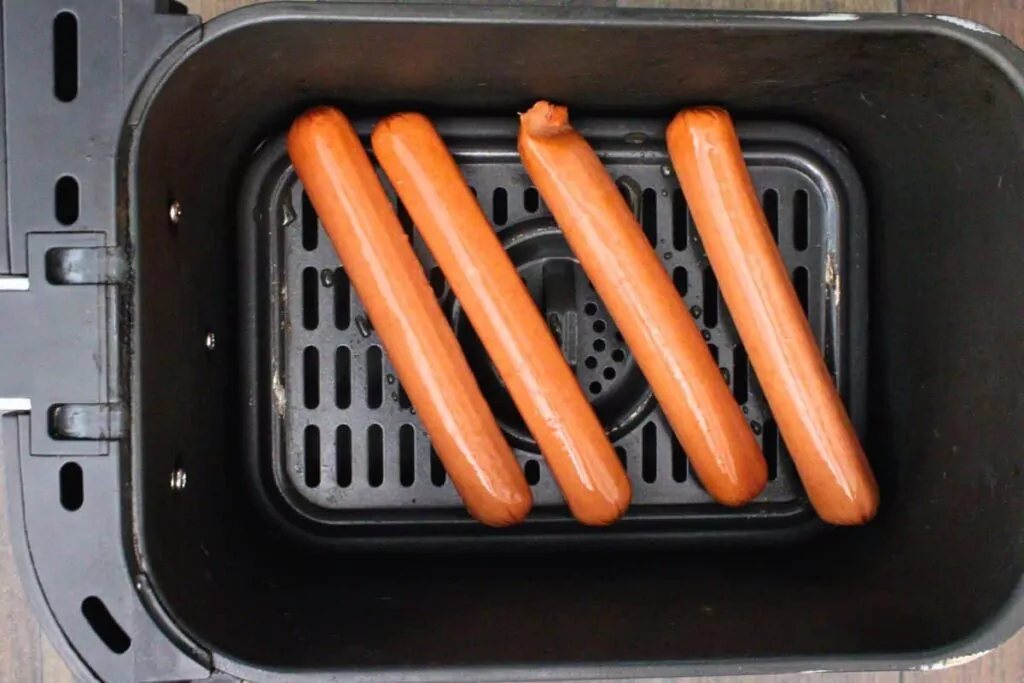 place hot dogs in air fryer basket leaving space in between