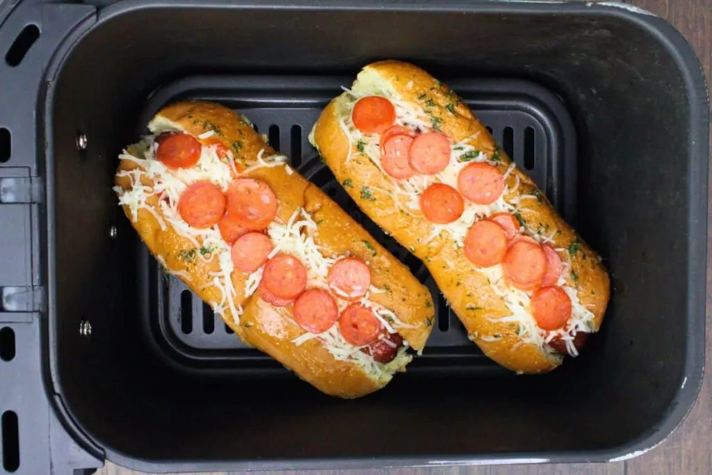 place pizza hot dogs back in air fryer basket to melt cheese