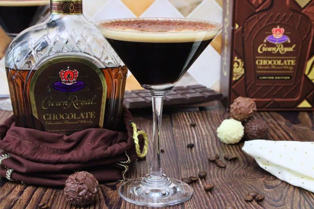 chocolate espresso martini with cocoa dusting next to chocolate crown royal bottle