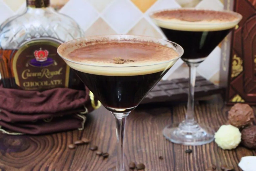 closeup of chocolate espresso martini with second martini in the background along with chocolate crown royal bottle