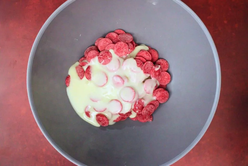 add red candy melts and sweetened condensed milk to microwave safe bowl