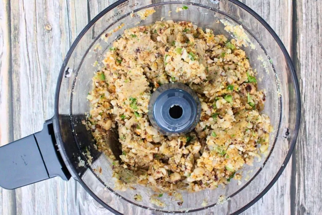 add black eyed peas, onion, pepper, garlic, breadcrumbs, egg, and seasoning to food processor