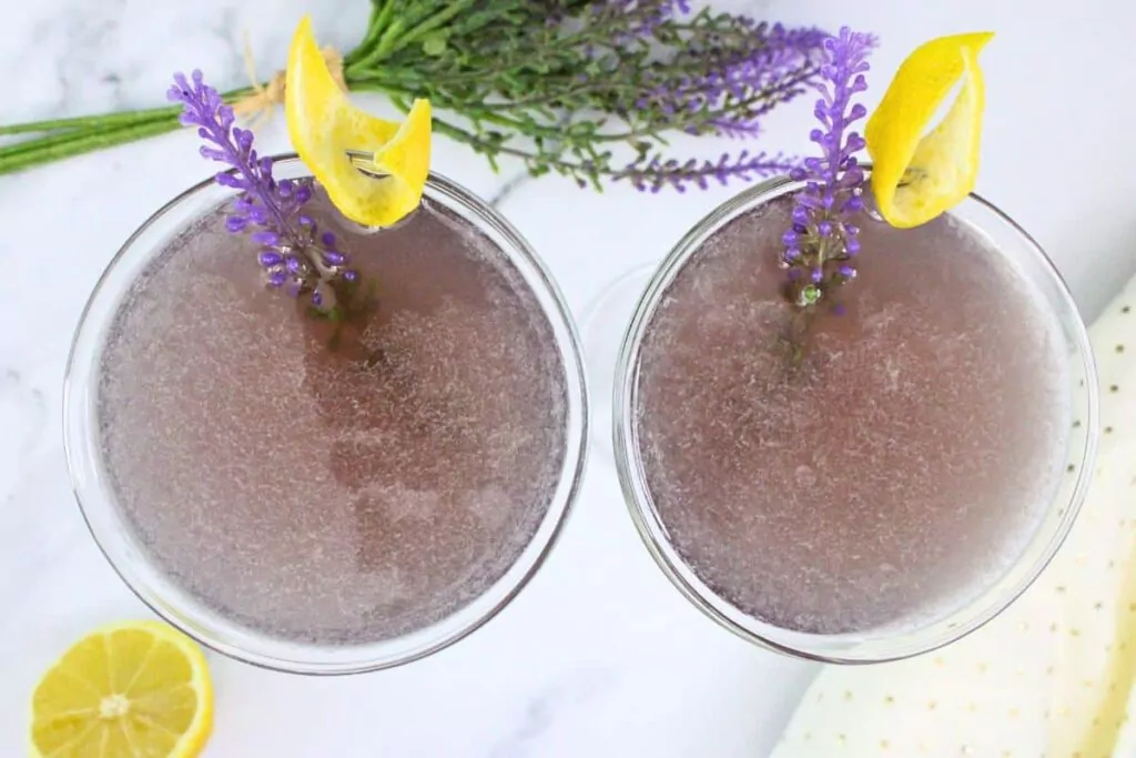 overhead view of two lavender bees knees garnished with lavender sprig and lemon peel