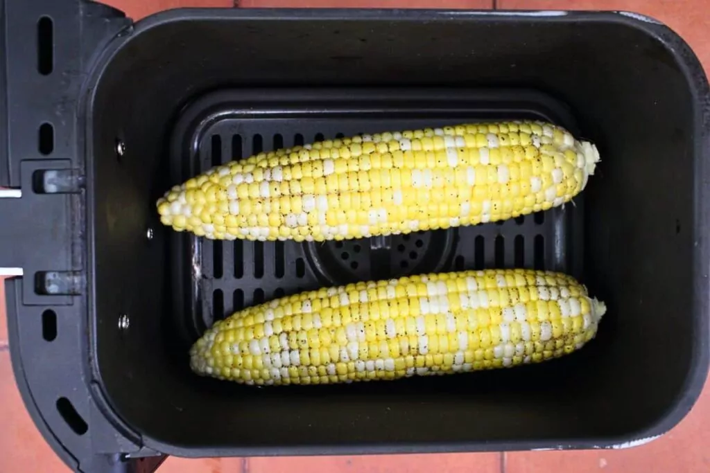place ears of corn brushed with olive oil and seasoned with salt and pepper in air fryer basket