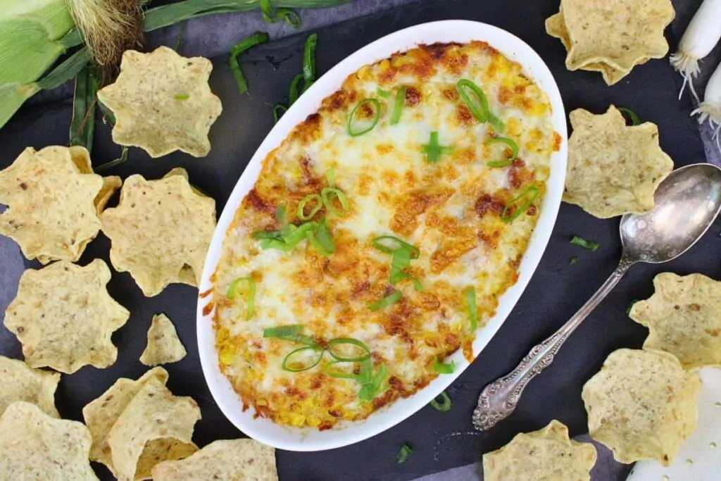 overhead view of korean corn cheese in a baking dish with tortilla chips scattered around